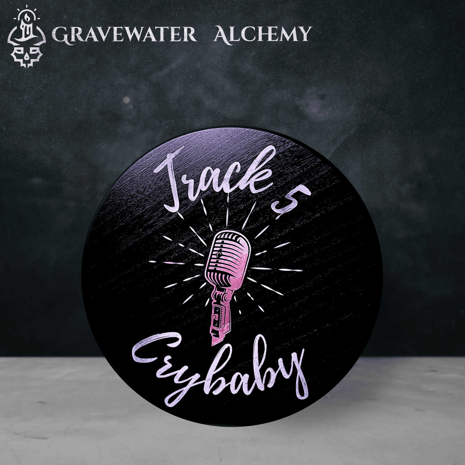 The Alchemist's Vault - The Crybaby Collection Circular engraved black wooden plaque featuring a radiant pink microphone surrounded by the words “Track 5 Crybaby.”