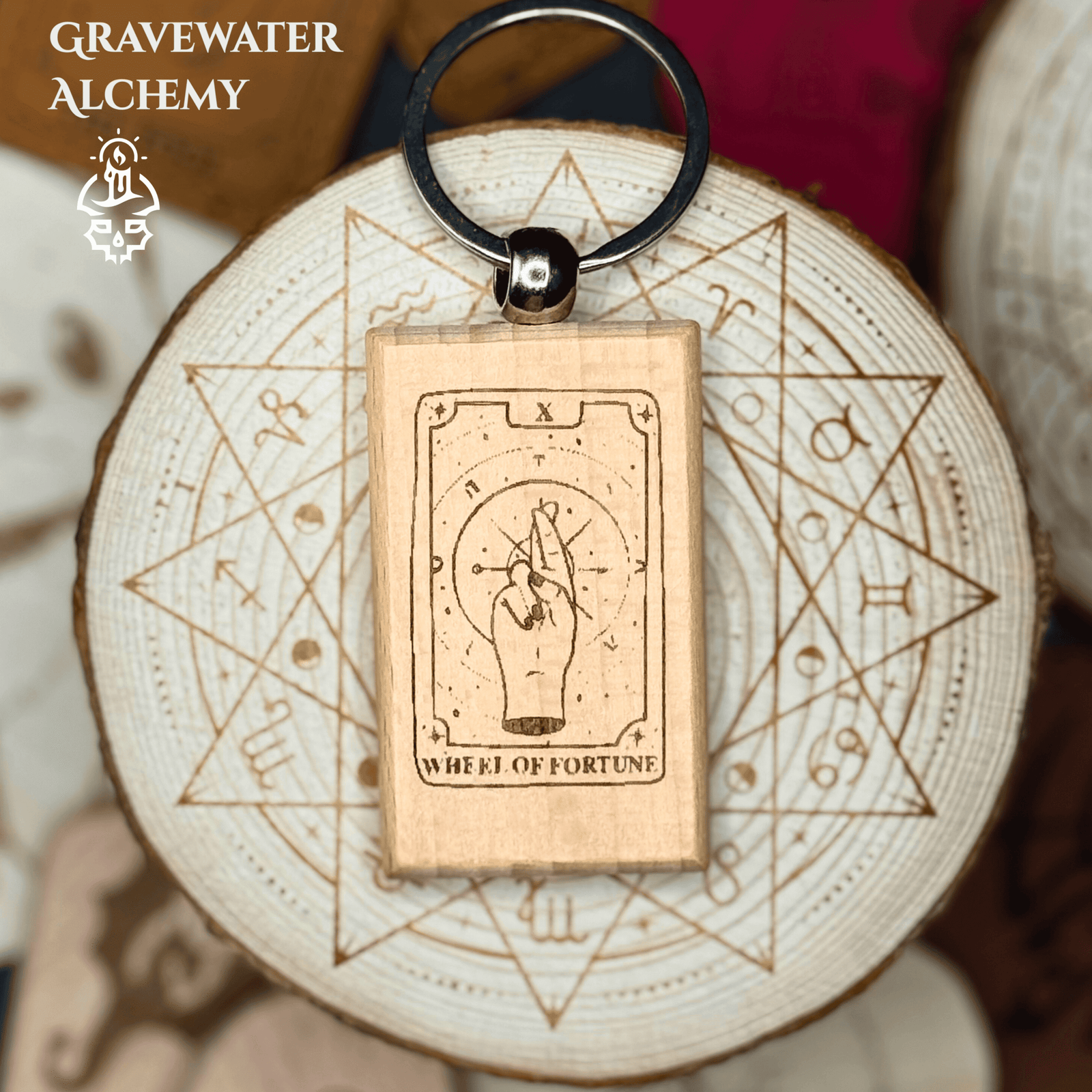 Wooden engraved Tarot keychain featuring Wheel of Fortune with hand and celestial symbols.